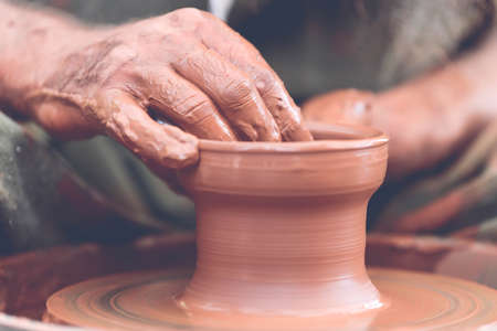 Hands of a potter. Potter making ceramic pot on the pottery wheelの写真素材