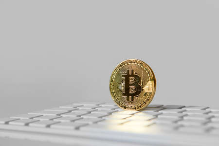 Bitcoin gold coin on white keyboard