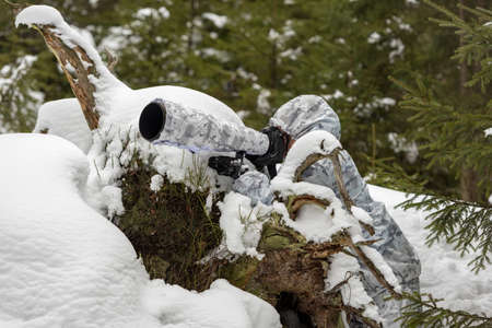 Wildlife photographer outdoor in winter. Photographer in winter camouflage