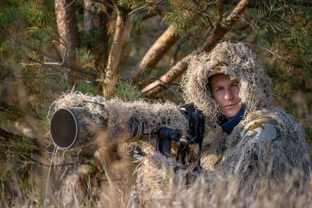Camouflage wildlife photographer in the ghillie suit working in the wildの写真素材