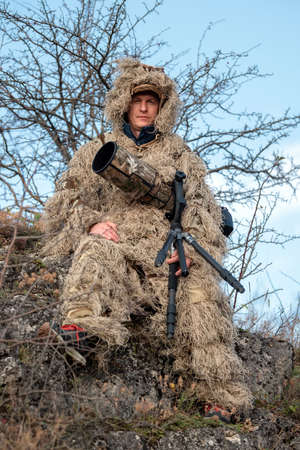 Camouflage wildlife photographer in the ghillie suit working in the wildの写真素材