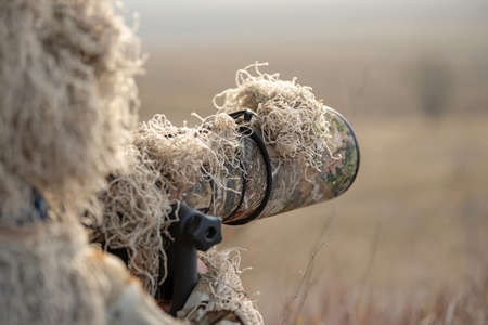 Camouflage wildlife photographer in the ghillie suit working in the wildの写真素材