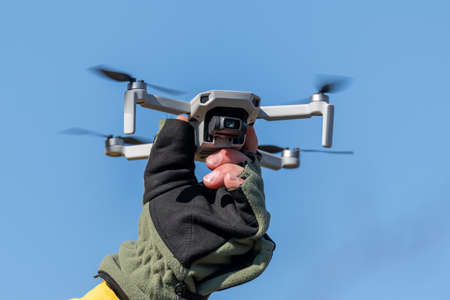 Drone Quadcopter during flight on a sunny day on blue sky backgroundの写真素材