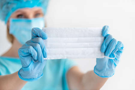 Doctor or nurse holding in hand with glove closeup face mask. Healthcare and medical concept to prevent the spread of the virusの写真素材
