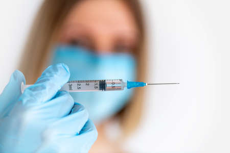 Syringe for injection in nurse hand. Medical glass vial for vaccination. Science equipment, liquid drug or vaccine. Medicine conceptの写真素材