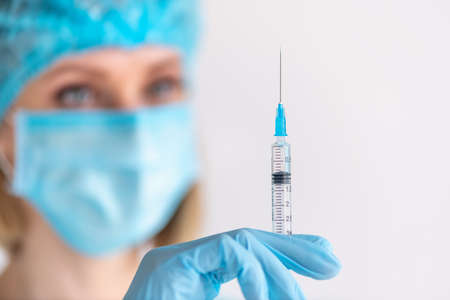 Syringe for injection in nurse hand. Medical glass vial for vaccination. Science equipment, liquid...