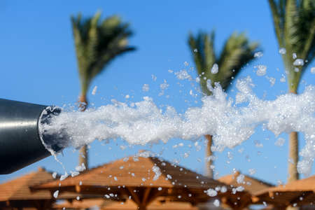 Fun foam party on the beach. Close foam on a blue sky background with palmの写真素材