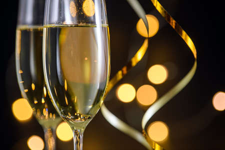 Two glasses of champagne or wine with bokeh background close up. New Year, Christmas mood. Greeting card. Party and holiday celebration conceptの写真素材