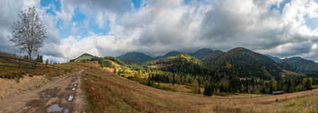 Autumn in mountain, amazing landscape with old dirt roadの写真素材