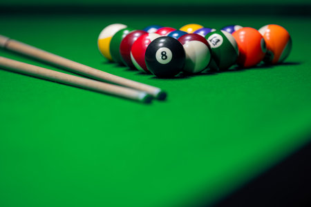 Close many colorful billiard balls and cue on green table