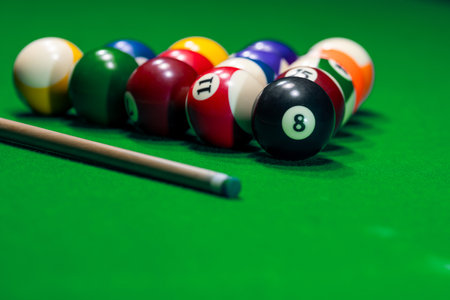 Close many colorful billiard balls and cue on green tableの写真素材