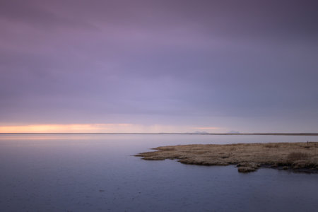 Tranquil landscape on a lake in Iceland at sunset with a mountain in the background and bluish tonesの写真素材