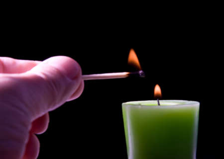 The hand with a match lights a candle