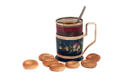 Glass of tea in a glass-holder and bagelsの写真素材