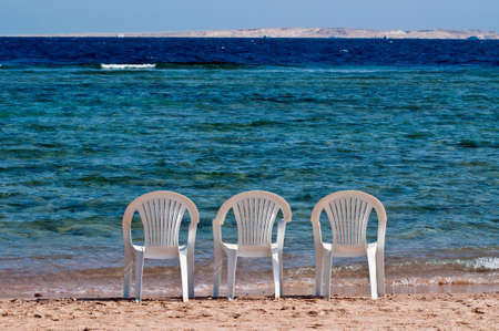 Three empty chairs on the beachの写真素材