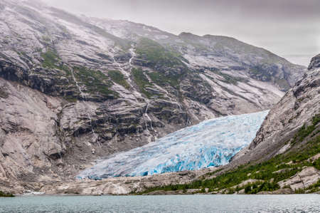 Jostedalsbreen glacier in Norway - melting because of Global warming. Left on a glacier visible group of tourists.の写真素材
