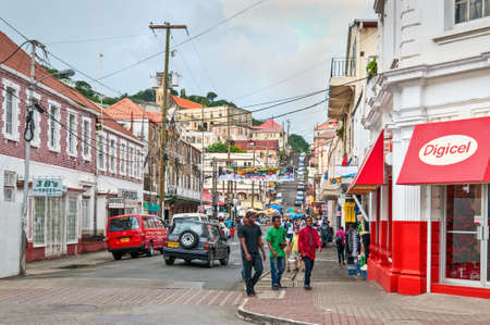 St. George's, Grenada - December 3, 2011: Scene of daily life in the capital of Grenada, with people walking on the sidewalks and traffic in the streets. The center of the city is crossed by steep, narrow streets full of shops and people.のeditorial素材