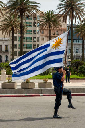 Montevideo, Uruguay - December 15, 2012: Police officer marching with flag at the Parade in Montevideo, Uruguay.のeditorial素材