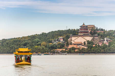 Beijing, China - October 14, 2013: Tourists visiting the Summer Palace are transported across the Kunming Lake on a motorboat. The boat has a large roof in ancient Chinese architectural style, the same as the Imperial pavilions and corridors of the Summerのeditorial素材