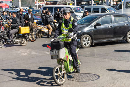Beijing, China - October 15, 2013: Chinese policeman patrol on motor scooters on a busy street in Beijing, China.のeditorial素材