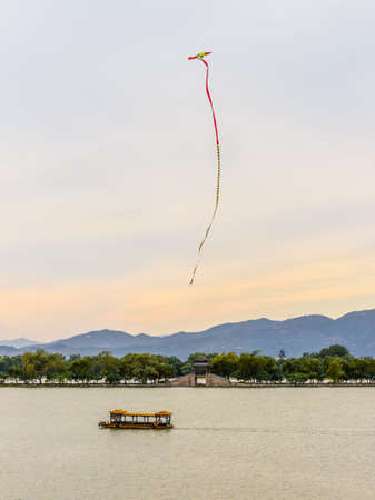 Beijing, China - October 14, 2013: Kite flying in the sky over the Kunming lake at the Summer Palace. Kiting is a very old Chinese tradition. 2,800 Years ago kites were already used in China, where materials ideal for kite building were readily available:のeditorial素材