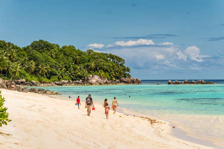 Anse Royale, Mahe Island, Seychelles - December 15,2015: People walking in the sand in Spectacular Anse Royale beach and in the background some people enjoying the Ance Royale Beach, Mahe Island, Seychelles.のeditorial素材