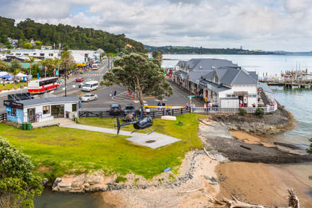 Paihia, New Zealand - November 21, 2014: Sightseeing Helicopter landed in foreground, Ferry Terminal on right.のeditorial素材