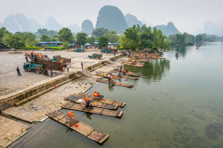 Yangshuo, China - October 20, 2013: Bamboo rafts on the  Li river in the rainy weather (overcast, nasty). Thousands of tourist visit yangshuo region in order to admire karst scenery and have Li river cruise in Yangshuo, China.のeditorial素材