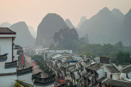 Yangshuo, China - October 21, 2013: View of evening city and mountains in Yangshuo, China.のeditorial素材