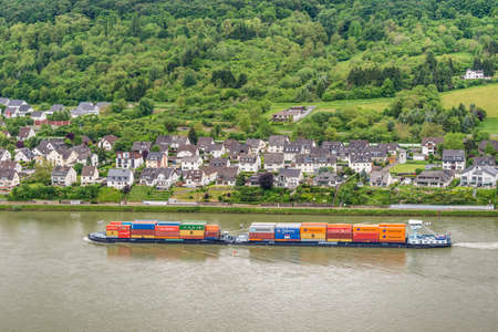Spay, Germany - May 23, 2016: Container ship on the Rhine River, Rhine Valley, UNESCO World Heritage Site, Germany. Spay is a municipality in the district of Mayen-Koblenz in Rhineland-Palatinate, western Germany.のeditorial素材