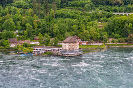 Neuhausen am Rheinfall, Switzerland - May 24, 2016: Rhine River at Rhine Falls and Castle Woerth in...