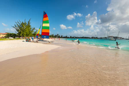 Bridgetown, Barbados - December 18, 2016: Brownes beach at ocean coast with people and colorful sail on a yacht at sunny day in Bridgetown, Barbados.のeditorial素材