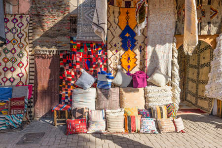 Marrakesh, Morocco - December 8, 2016: Textiles for sale in the famous souks of Marrakesh, Morocco, Africa. The sun's rays on the carpets.のeditorial素材