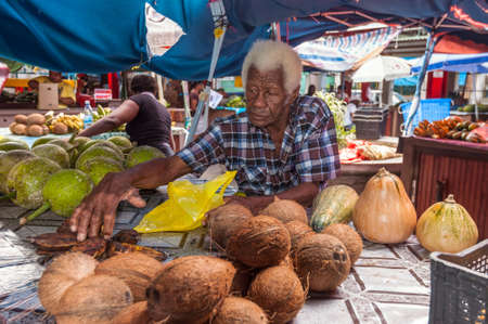 Victoria, Mahe, Seychelles - December 16, 2015: Sellers offer fresh fruits in the Sir Selwyn Selwyn Clarke Market. Built in 1840 and renovated in 1999, it remains the bustling heart of the capital and definitely the best place to buy fresh fruits, fish, vのeditorial素材