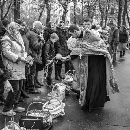 Kyiv, Ukraine - April 16, 2017:  Priest blessing the happy people during Holy Easter Sunday ceremony outside St Volodymyr's Cathedral in Kyiv, Ukraine. Black and white photography.のeditorial素材