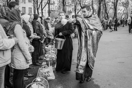 Kyiv, Ukraine - April 16, 2017:  Priest blessing the happy people during Holy Easter Sunday ceremony outside St Volodymyr's Cathedral in Kyiv, Ukraine. Black and white photography.のeditorial素材