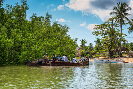 Ambatozavavy, Nosy Be, Madagascar - December 19, 2015: Locals on the traditional wood pirogue with outrigger on the shore of the fishing village on the Nosy Be island, Madagascar.のeditorial素材