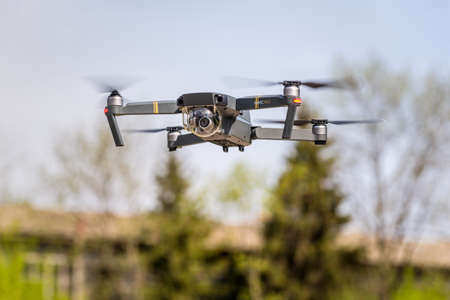 Kyiv, Ukraine - April 29, 2017: Drone quadrocopter DJI Mavic Pro flying against the background of sky and trees. Safe tool for aerial photo and video.のeditorial素材