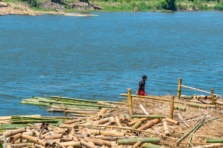 Toamasina, Madagascar - December 22, 2017: Unidentified Madagascar man is working on bamboo harvesting on the river near the city of Toamasina (Tamatave), Madagascar, East Africa. Everyday life on the river.のeditorial素材