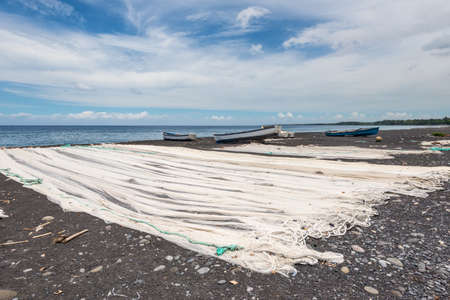 Fishing nets drying on the black beach on the La Reunion island in the Indian ocean - Franceの写真素材