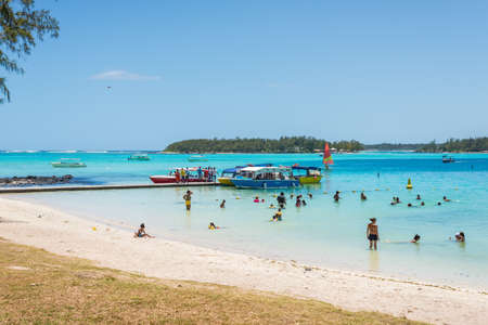 Blue Bay, Mauritius - December 27, 2015: Unidentified people on the beach and pier in the Blue Bay, one of the finest beaches in Mauritius and the site of many tourism facilities.のeditorial素材