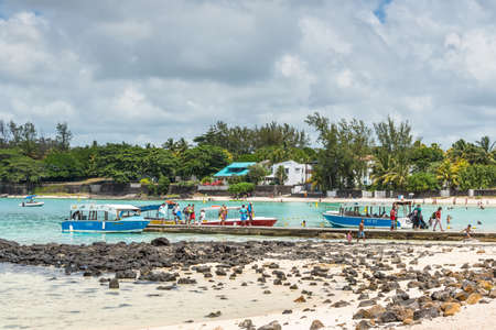 Blue Bay, Mauritius - December 27, 2015: Unidentified people getting off boat and walking on pier in the Blue Bay Beach, one of the finest beaches in Mauritius and the site of many tourism facilities.のeditorial素材