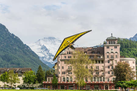 Interlaken, Switzerland - May 26, 2016: Tandem on the Hang Glider landing against the background of the Swiss Alps in Interlaken, Switzerland.のeditorial素材