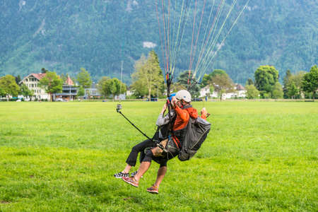 Interlaken, Switzerland - May 26, 2016: Tandem paragliding landing after flight over the Swiss Alps in Interlaken, Switzerland.のeditorial素材