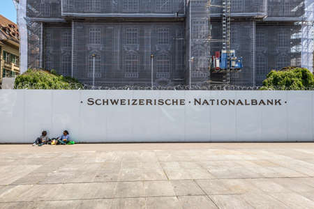 Bern, Switzerland - May 26, 2016: People are resting near National Bank of Switzerland in Bern, Switzerland. Building facade covered for restoration work.のeditorial素材