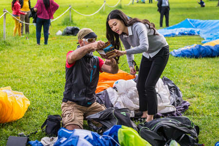 Interlaken, Switzerland - May 26, 2016: Paragliding instructor shows the girl the advertising of paragliding in Interlaken, Switzerland.のeditorial素材