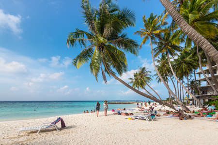 Maafushi Island, Maldives - November 17, 2017: People enjoying sunny day in a tropical beach of the Maafushi Island in Maldives, Indian Ocean.のeditorial素材