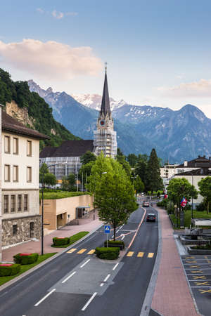 Vaduz, Liechtenstein - May 28, 2016: A view of the city with snowy Alp mountains and Cathedral of St. Florin on the Sunset in Vaduz, Liechtenstein.のeditorial素材