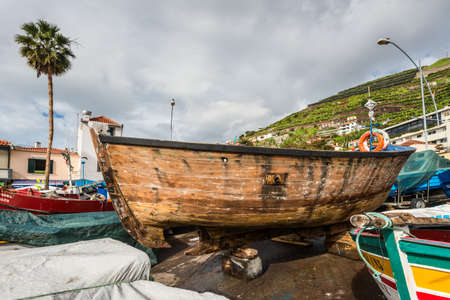 Camara de Lobos, Madeira, Portugal - December 10, 2016: A wooden fishing boat on the shore of fishing village Camara de Lobos near Funchal, Madeira Island, Portugal.のeditorial素材
