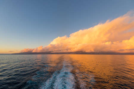 Clouds illuminated by the sun over the Madeira island in the Atlantic Ocean at sunset. Nature...